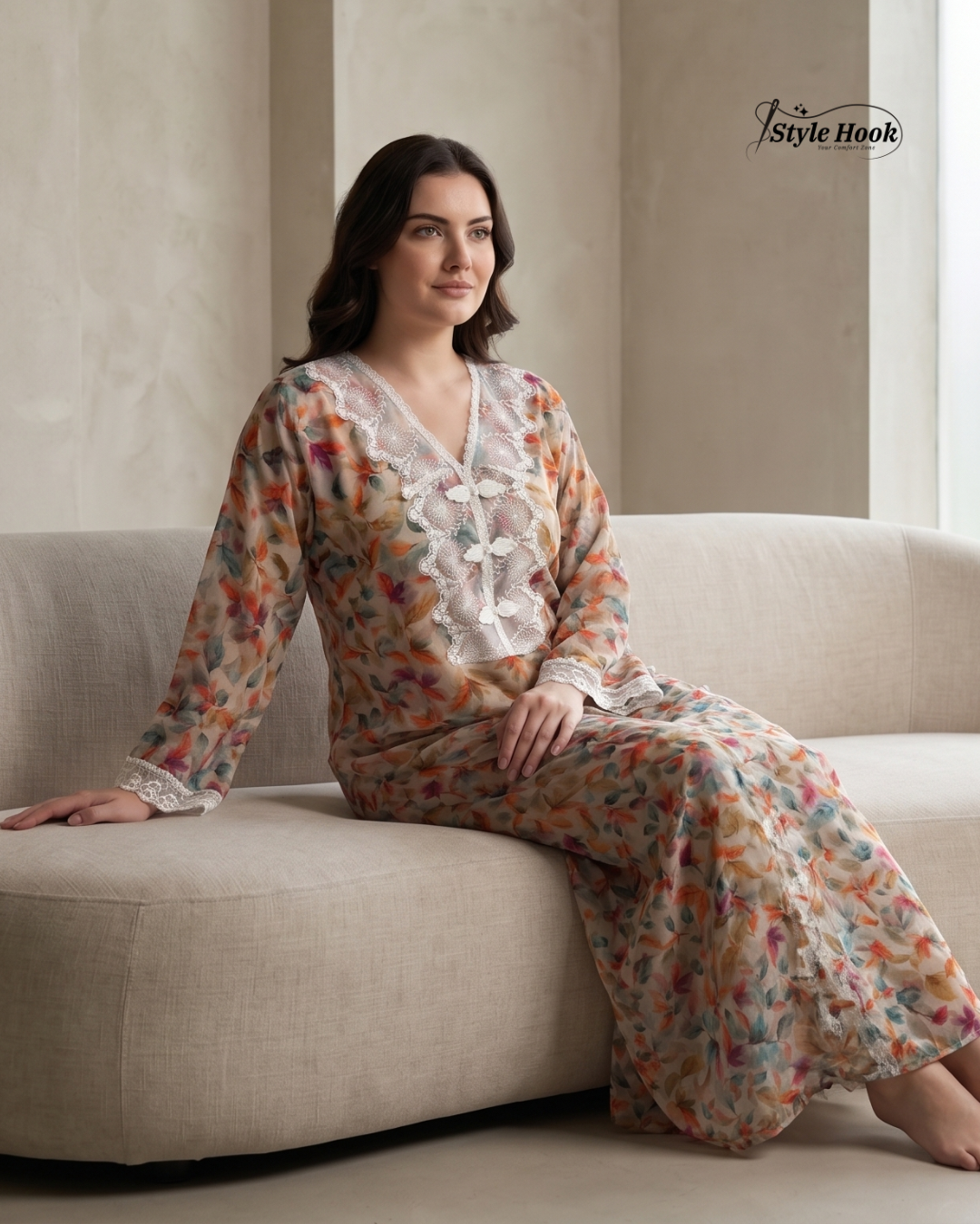 Woman in a floral outfit sitting on a couch with a neutral background