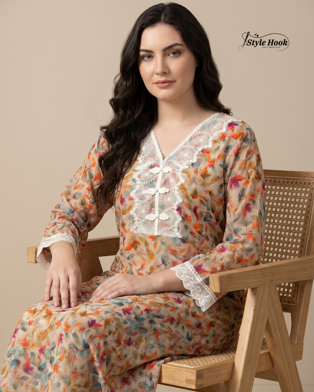 Woman wearing a floral dress sitting on a wooden chair with 'Style Hook' branding.